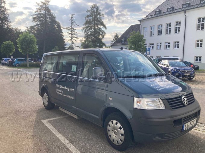 Ansicht Fahrzeug von schräg vorne und rechte Seite. An der rechten unteren Seite befindet sich die eingefahrene Trittstufe. Außerdem ist noch die schwarze Kunststoffstoßstange zu sehen.