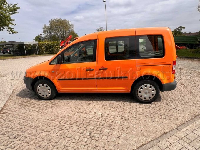 Das orangefarbene Kommunalfahrzeug ist hier seitlich von der Fahrerseite her fotografiert. Bei genauem Hinschauen erkennt man die bereits erwähnten verrosteten Schweller.