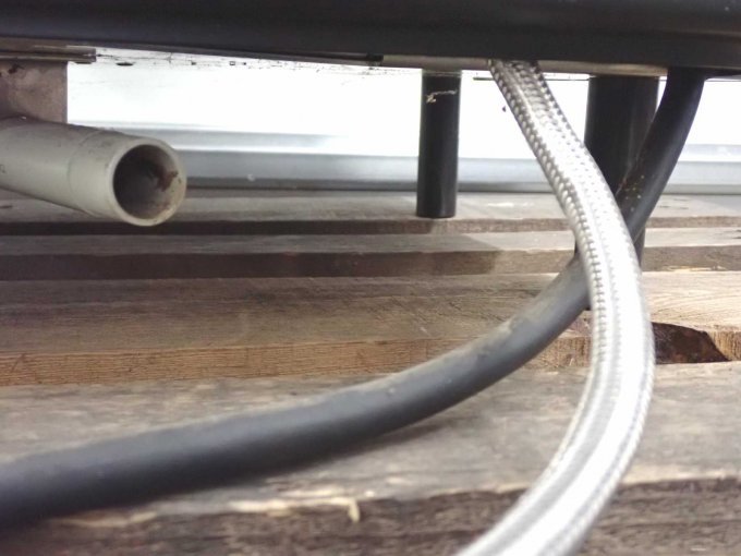 Unterseite der Kaffeemaschine mit Schläuchen und Plastikrohr