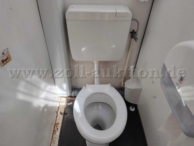 Ansicht von Innen auf ein Stand WC von oben mit sich auf die Metallleiste vom Fußboden mit Roststellen.