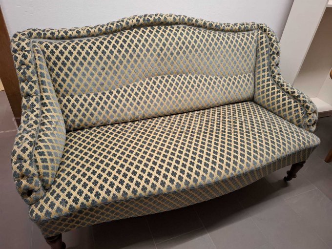 Vollgepolsterte Couch. Farbe beige-grau/blau. Frontsicht.