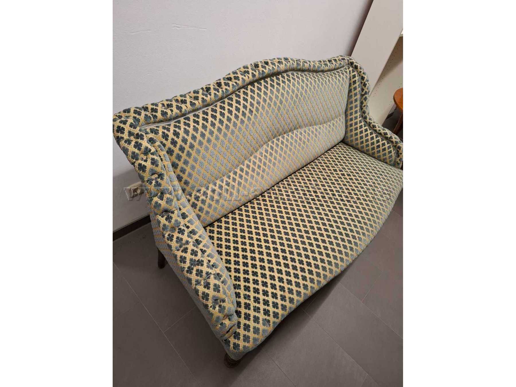 Vollgepolsterte Couch. Farbe beige-grau/blau. Leicht seitliche Sicht.