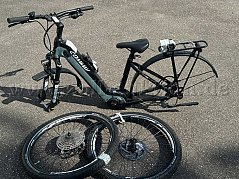 Ansichtsbild 1 E-Bike Conway Cairon SUV 527 mit davorliegenden Rädern und Pedalen (auf dem Gepäckträger).