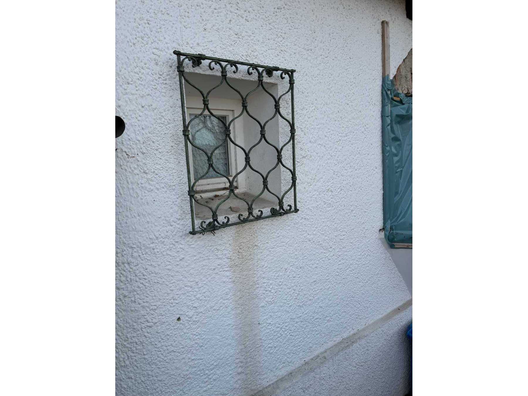 Zu sehen ist das Fenstergitter mit witterungsbedingten Abnutzungen.