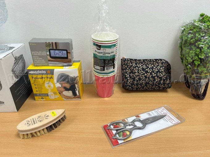 LCD-Wecker von Tchibo, Milchpumpe von medela, Gemüsebürste und Pappbecher von unbekannten Marken, Kosmetiktäschchen von Vito & Joe, Küchenschere von Burgvogel