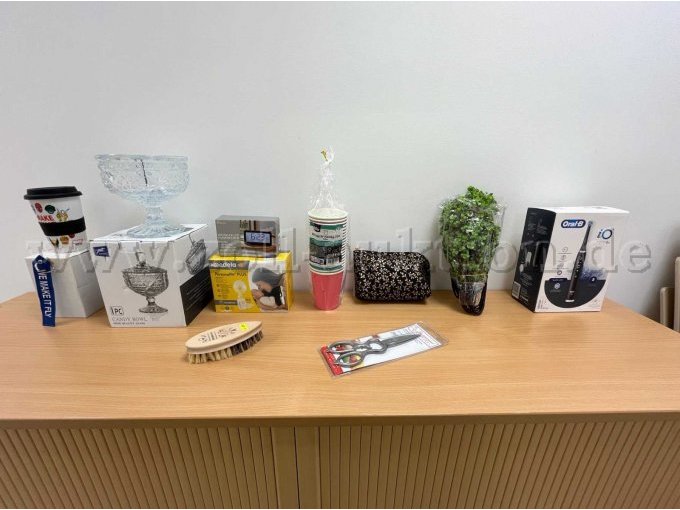 Links nach rechts: Coffee to go Becher, Schlüsselanhänger, Glasschale mit Deckel, Gemüsebürste, Milchpumpe und Wecker, Pappbecher, Kosmetiktäschchen, Küchenschere, Kunstpflanzen, Elektro-Zahnbürste