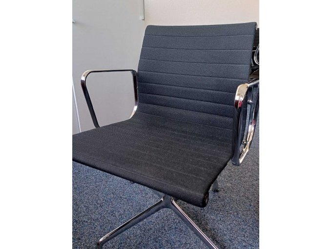 Seitlicher Blick auf den Stuhl Vitra Aluminium von Charles und Ray Eames EA 108 mit verchromten Armlehnen