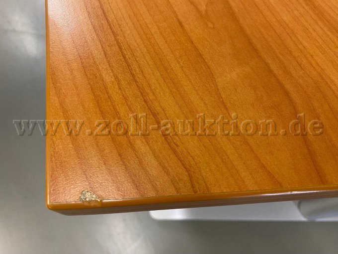 Am Rand der Tischplatte ist eine größere Stoßkante sichtbar.
