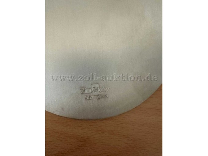 Rückseite des Zinntellers mit Herstellerprägung und der Materialangabe