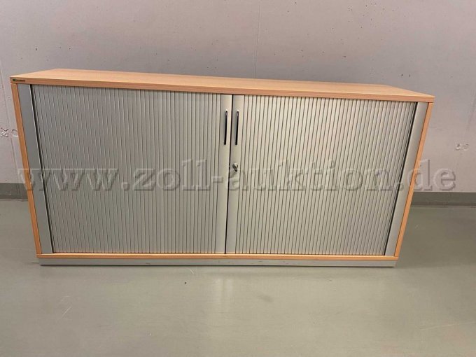 Der Querrolladenschrank ist in einem guten Zustand, weist aber alterstypische leichte Kratzer auf der Oberfläche auf.