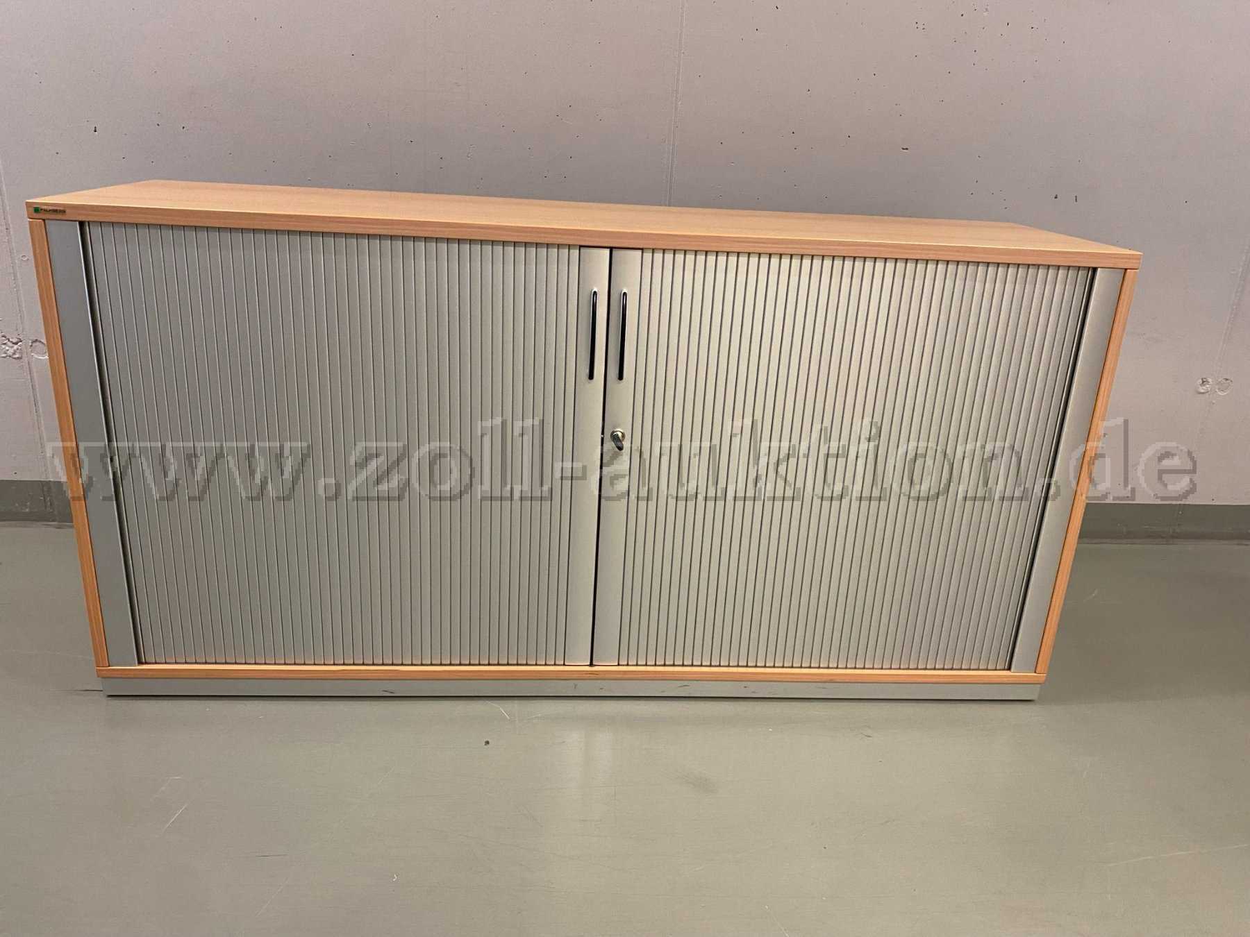 Der Querrolladenschrank ist in einem guten Zustand, weist aber alterstypische leichte Kratzer auf der Oberfläche auf.