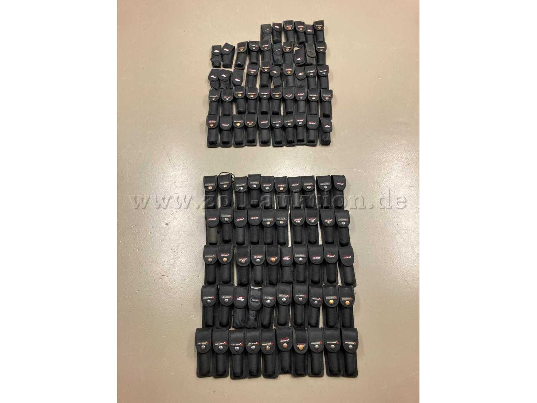 Übersichtsaufnahme, unten die 50 Holster mit Taschenlampen, oben die 46 leeren Holster